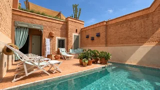 La piscine ensoleillée et ses chaises longues