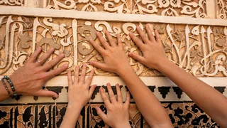 Des mains posées sur un décor sculpté de Marrakech