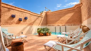 Des chaises longues au soleil près de la piscine