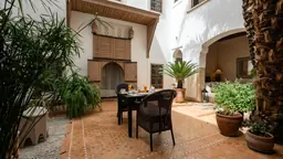 Une table à l’ombre des plantes du patio